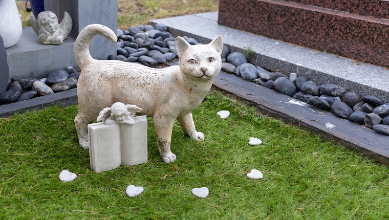 Grave of a cat, stone cat statue in the pet cemetery, RIP