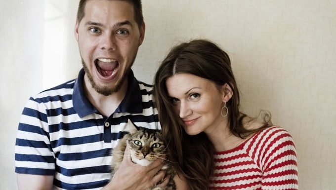 couple holding a cat. man is yelling.