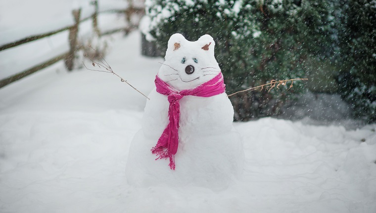 A snowman made in the shape of a cat.