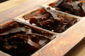 Biltong (dried meat) on a wooden board, this is a traditional food snack that can be found in South Africa.