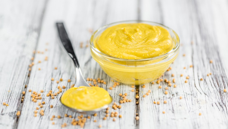 Mustard as high detailed close-up shot on a vintage wooden table (selective focus)