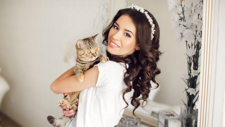 smiling bride with cat at wedding