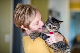 woman hugging cat