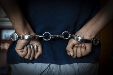 A woman handcuffed, similar to the one who was arrested for leaving cats in horrible conditions in an apartment in Iowa.